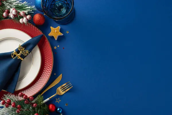 Opulent New Year\'s dinner arrangement in cafe, showcasing top-view plates, gold cutlery, napkin ring, wine glass, baubles, candle, confetti, frosted fir twigs, mistletoe, text space on blue backdrop