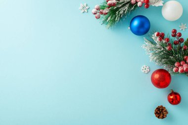 Bu imajdan esinlenerek başarının şerefine. Muhteşem renkli süslemelerin üst görüntüsü, buzlu çam dalları, kutsal meyveler, yumuşak mavi tuval üzerinde kar taneleri, metin veya promosyon için yer sağlar.