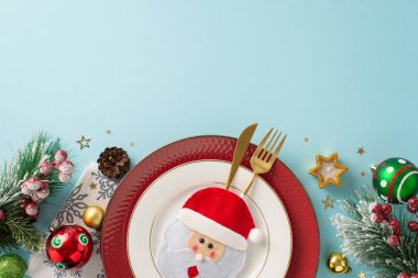 Tuhaf çatal bıçak, tabak, sevimli peçete, parlak mücevherler, yıldız şeklinde mum, dağınık konfeti, buzlu köknar dalları, kutsal böğürtlenler, mesajınız için yumuşak mavi fon.