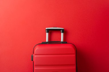 Tatil kaçamağı kavramı. Bavulların yukarıdan aşağıya bakışı, kışın inzivaya çekilme yolculuğunu temsil eden, kırmızı bir arka planda, mesajınız veya reklamınız için boş bir alan.