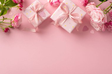 Love Tokens: Hediye kutuları, pembe güller ve kalp konfetilerinden oluşan üst görünüm kompozisyonu. Metin için geniş alanı olan pembe arkaplan