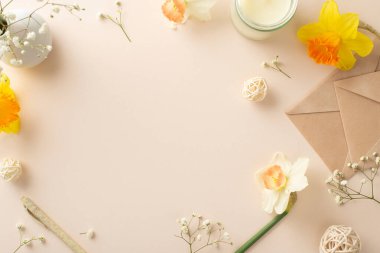 En içten bahar dileklerini nergis ve çingenelerle gerçekleştir. Üst görünüm çiçekleri, bir zarfı, aroma mumunu ve dekoru sakin bir bej izole arka planda yakalar, reklam veya metin için hazırdır