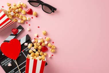 Sevgililer Günü film sihri. Üst görüntü, deklanşör, 3 boyutlu gözlük, patlamış mısır kutuları, kalp şeklindeki süsler, şekerler, şekerlemeler, sevimli pastel pembe yüzeye serpiştirilmiş şekerlemeler, rüya gibi bir atmosfer yaratıyor.