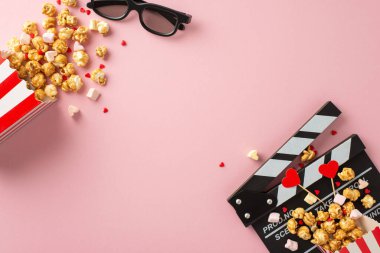 Sevgililer Günü sinema randevusu sahnesi. Alkış tahtası, 3D gözlükler, çizgili patlamış mısır kutuları, kalp temalı dekorasyonlar, şekerlemeler ve tatlı pastel pembe arka planda serpiştirilmiş şekerlemeler.