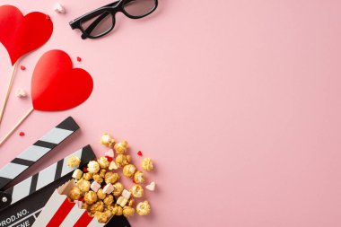 Sevgililer Günü 'nün film sihri: üst görünüm klaket tahtası, 3 boyutlu gözlük, patlamış mısır, kalp dekoru, marşmelov ve büyüleyici pastel pembe bir dekor üzerine serpiştirilmiş şekerlemeler. Aşkı her karede yakala