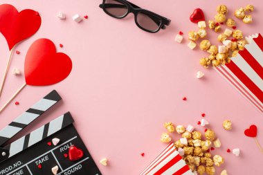 Her karede aşk. Alkışların üst görüntüsü, 3D gözlükler, patlamış mısır kutuları, kalp temalı dekorlar, şekerlemeler, şekerlemeler, pastel pembe arka planda güzelce düzenlenmiş şekerlemeler, kişisel mesajlar için alan