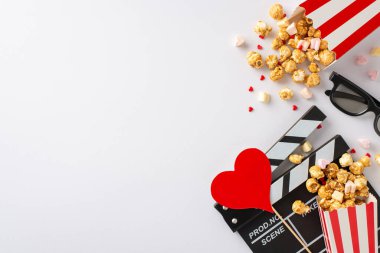 Evde Sevgililer Günü film festivali var: Clapperboard, 3D gözlükler, patlamış mısır, kalp dekoru, lokum ve tatlı beyaz bir yüzeye serpiştirilmiş şekerlemeler. Mükemmel bir gece için romantik ortam
