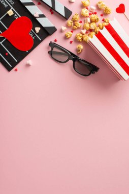 Romantik film maratonu seti: Dikey üst görünüm, 3D gözlükler, patlamış mısır, kalp dekoru, marşmelov ve enfes bir pastel arka planda serpiştirmeler. Aşkı her karede kutla