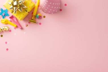 Güzel bir doğum günü gösterisi fikri. Çekici dekorlar, şekerler, paketlenmiş hediyeler, kutlama şapkası, pipo, balonlar, konfetiler, soluk pembe arka planda yılanbalığı içeren şenlik masası. Metin dostu boşluk