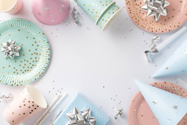 Üst görüş perspektifinde dizayn edilmiş doğum günü tablosu, gösterişli kağıt masa takımı, hediye, doğum günü şapkaları, pipetler, gümüş pullar, kurdele yıldızları, yılan, beyaz yüzeyde düzenlenmiş, metin alanınız için boşluk