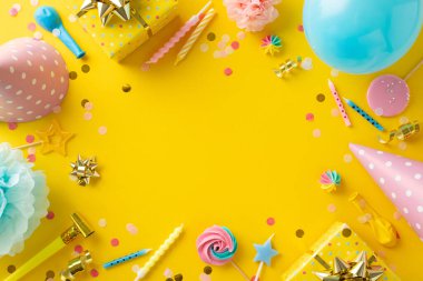 Güzel bir doğum günü ilham kaynağı. Neşe dolu dekorlu resim masası, merengue şekerlemeleri, hediyeler, şapkalar, mumlar, balonlar, konfeti, sarı zemin üzerinde yılan. Metin dostu boşluk
