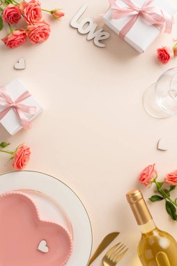 Her ayrıntıda aşk: dikey üst görünüm kalp şeklinde tabak, çatal bıçak takımı, beyaz şarap, güller, hediye ve pastel bej arka planda bir 