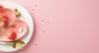 Hayalperest Sevgililer Günü atmosferi: Üst manzara fotoğraf sergisi büyüleyici yemek düzeneği. Kalp şeklinde tabak, çatal bıçak takımı, güller, serpiştirmeler ve pastel pembe arka planda temalı dekor, metin veya tanıtım için boşluk