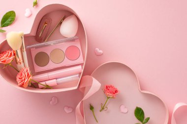 Dudak parlatıcısı, göz farı, rimel, güzellik blenderi ve saç tokaları gibi güzellik hazinelerinin yer aldığı kalp şeklinde bir kutuyla vermenin hazzını keşfedin. Pastel pembe arka planda güller ve kalplerle üst manzara
