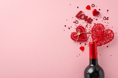 Valentine 'ın cazibesinin tepeden tırnağa görüntüsü. Şarap şişesi, kalp şeklinde konfeti ve renkli pembe bir dekor. Romantik dokunuşlu mesajlar ve reklamlar için mükemmel.