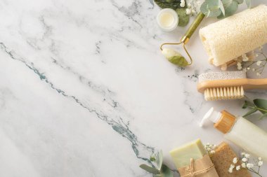 Gua sha, krema kavanozu, losyon şişesi, banyo lifleri ve doğal mermer taşlı seti. Metin ve reklamlar için boş alan. Bu doğal vücut bakım konseptiyle markanızı yükseltin.