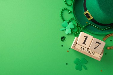 Bir çerçevede St. Paddy 's şenlikleri: Ahşap bir takvim, leprikon şapka, şanslı at nalı, trefolyo, konfeti ve yeşil arkaplan üzerindeki boncuklar