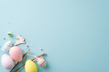 Radiate Easter vibes with this enchanting top view picture displaying lively eggs, sweet bunny, pussy willow, sugar sprinkles, on pastel blue background. Ample space for your text or promo content