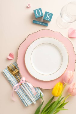 Kadınsı temalı yemek masası tasarımı. Sofistike tabakların dikey görüntüsü keten peçete, sofra takımı, kırmızı şarap bardağı, güzel laleler yumuşak bej tuval üzerinde daimi takvim, reklam için alan.