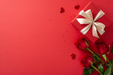 Kadınlar için şık bir sunum: üst görünüm gül buketi, motif hediye kutusu, kalpler ve konfeti karışımı, hepsi de yazmak için boş bir yer ve boş bir kırmızı arka plan üzerine kurulmuş