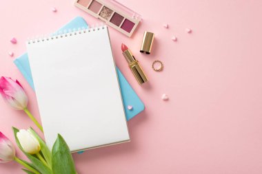 Taze lalelerin üst görüntüsü, şık defterler, göz farı paleti, ruj, yüzük ve pastel pembedeki kalpler. Metin ve reklamlar için yeri olan mükemmel kadın konseptini benimse