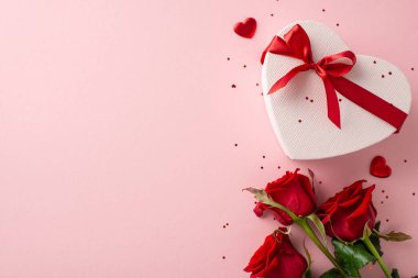 Mükemmel kadınsı jübile iskeleti: Zarif gül topluluğunun üstten görünüşü, şık kalp kutusu, dekoratif eşyalar, soluk pembe arka planda parıltı, yazı içeriği için kasten boşluk bırakılmış.