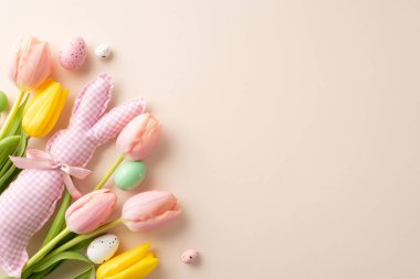 Bunny Bliss: Canlı yumurtalar, neşeli tavşan oyuncakları ve bej arka planda üst görüşe yerleştirilmiş laleler. Bu Paskalya esinlenilmiş resim metin veya tanıtım içeriğiniz için mükemmel tuval sağlar