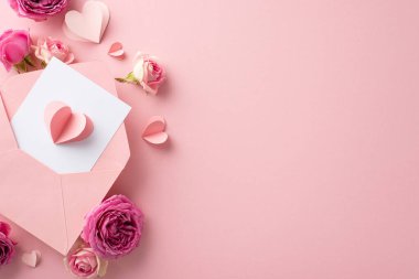 8 Mart dilek konsepti. Kırık zarfın genel görünüşü, yürekten tebrik kartı, hassas kağıt kalpler, pembe yüzeyde serpilmiş gül çiçekleri, metin ya da reklam için yer sağlar.