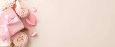 Güller, kalp süsleri ve zarif paketlenmiş hediyelerin yer aldığı göz kamaştırıcı bir üst görünüm düzenlemesi. Hepsi de narin arka plana karşı. Özel notlarınız ya da tanıtım içeriğiniz için boşluk