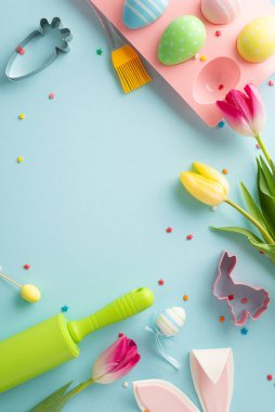 Paskalya ziyafeti çekiyoruz. En üstteki dikey fotoğrafta mutfak malzemeleri, eğlenceli kurabiye kesiciler, tutacakta yumurtalar, serpiştirmeler, tavşan kulakları, laleler var. Metin için alanı olan mavi arkaplan