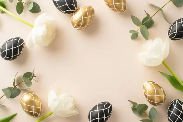 stock image Elegant Easter setup: top view of premium black and gold eggs, fresh eucalyptus leaves, tulip blossoms, on a light beige background, designed with space for text