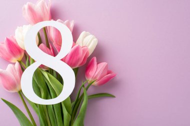 Uluslararası Kadınlar Günü görüntüsü. Üst görünümde 8 rakamı gösteriliyor. Pastel bir leylak yüzeyindeki lalelerin yemyeşil bir karışımı. Kelimeler için yeri var.