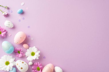 En tepeden çekilmiş Paskalya fotoğrafında yumurta, papatya çayı ve pastel bir leylak tuval üzerinde konfeti var. Tebrik veya promosyon malzemesi için yer var.