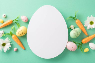 Paskalya 'nın yaratıcı tablosu: Yukarıdan bakıldığında yumurta, tavşan havucu ve turkuazda papatya filizleri, yumurta şeklinde notlar veya reklamlar için yoksunluk.