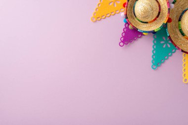 Cinco de Mayo esansı. Yukarıdan aşağıya manzara şenlik elementlerini yakalar: sombrerolar, bayrak dekoru, Pastel mor bir yüzeye dizilmiş, kelimeler için boşluk