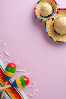 Cinco de Mayo 'nun, ikonik sembollerin dikey üst görüntüsüyle tadını çıkarın: şapkalar, Meksika perküsyon aletleri, mor tuval üzerinde çizgili bir battaniye.