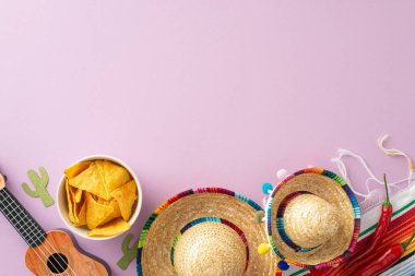 Cinco de Mayo için bir fotoğraf, neşeli sombrerolar, yaylı vihuela, desenli bir serape, acı biber ve pastel mor bir yüzey üzerinde nachos