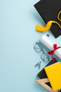 Mezuniyet şapkası, rulo diploma, gözlük, kitap, cetvel, nazik mavi arkaplan klipleri, kişisel notunuz veya promosyon içeriğiniz için ideal bir düşey görüntü ile bu olayı işaretleyin