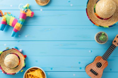 Cinco de Mayo temalı ekran: parlak ahşap arka planda sombreros, vihuela, kaktüs, lama pinata, nachos ve konfeti manzarası. Promosyon malzemeleri için mükemmel.