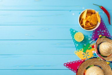 Cinco de Mayo kutlamalarının esasları. Geleneksel sahne donanımları: sombreros, bayrak çelengi, limon, biber ve ahşap mavi arka planda sergilenen nachos. Şenlikli reklamlar için mükemmel.