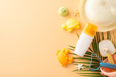 Hasır şapka, güneş kremi, güneş gözlüğü, oyuncaklar ve pastel arka planda tropikal palmiye yaprağı da dahil olmak üzere yaz mevsiminin temel gereklilikleri.