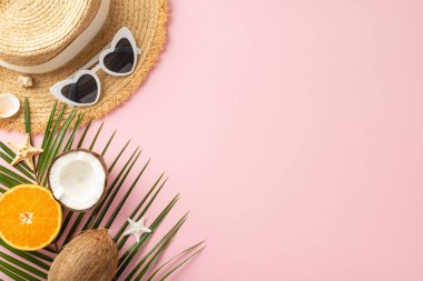 Hasır şapka, güneş gözlüğü, hindistan cevizi ve turuncu gibi canlı pembe arka planda seyahat promosyonu için mükemmel olan yaz tatili esaslarını içeren yaratıcı bir tasarım.