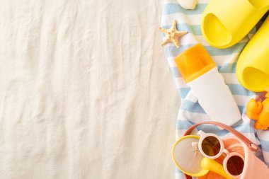 Sahildeki ufaklıkları koruyorum. Kum temizleme losyonu şişesinin en üst görüntüsü: kova, kürek, güneş gözlüğü, terlik, havlu ve daha fazlası. Mesajınız için kumsal arka planı