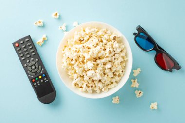 Patlamış mısır, 3D gözlük ve pastel mavi arka planda uzaktan kumandalı ev yapımı film gecesi üst görünümü. Samimi toplantılar için mükemmel. Metin ya da ilan ekle