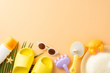 Çocuklar için yaz plajı eğlence düzeni: kürek, tırmık, deniz yaratığı kalıpları, SPF kremi, hasır şapka, güneş gözlüğü, küçük terlikler, deniz kabuğu, denizyıldızı, pastel arka planda palmiye yaprağı