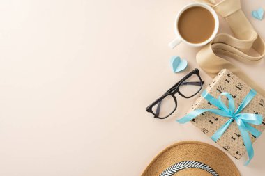 Bir Babalar Günü hediyesi, kurdele, kahve fincanı, bardaklar ve kalpler açık bej renkli pastel arka planda, sıcaklığı ve takdiri iletiyor.