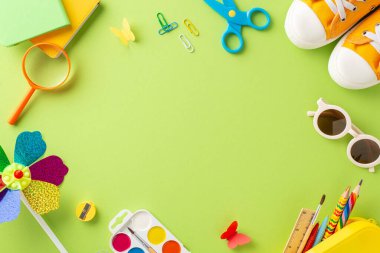 Yazın açık hava öğrenme teması. Resim malzemeleri - pastel boya, suluboya, klipler, makas, kitaplar, gölgeler, ayakkabılar, fırıldak ve yumuşak yeşil zeminde kelebekler. Metin veya tanıtım için boşluk