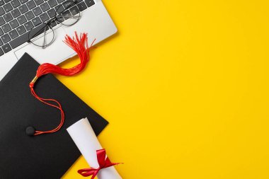 Kırmızı püsküllü, diplomalı, gözlüklü ve sarı arka planda online eğitim ve mezuniyet başarılarını sembolize eden bir laptop içeren canlı bir kurulum.