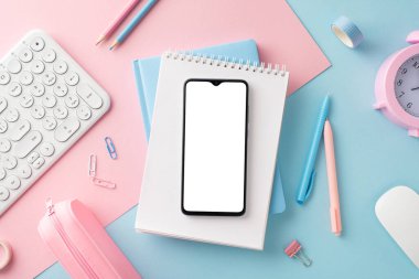 Bir akıllı telefon, not defteri, kalem ve pastel renkli aksesuarların iyi organize edilmiş bir şekilde sınıflandırıldığı şık bir masa düzeneği.