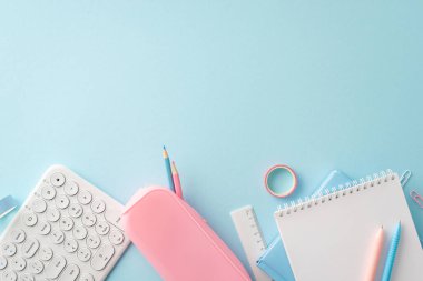 Canlı mavi ve pembe okul malzemeleriyle iyi organize edilmiş bir öğrenci çalışma alanı, defterler, kalemler, hesap makinesi ve verimli bir çalışma oturumu için daha fazlası var.